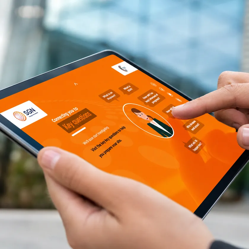 Hands holding a tablet showing an orange illustrated eLearning module with interactive options